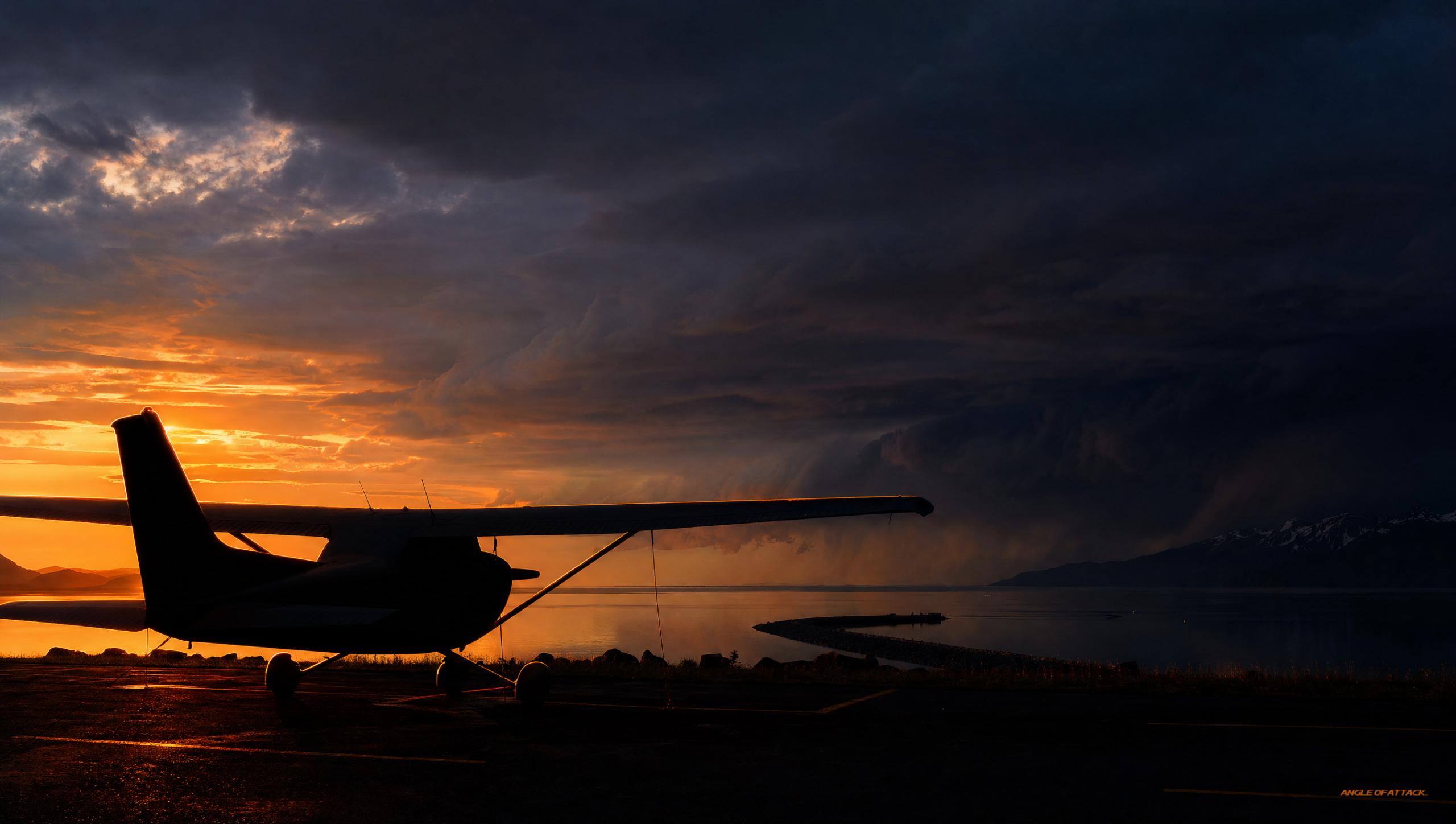 A Cessna 172 parked on a Homer, Alaska ramp as a dark line of building weather stands off across Kachemak Bay