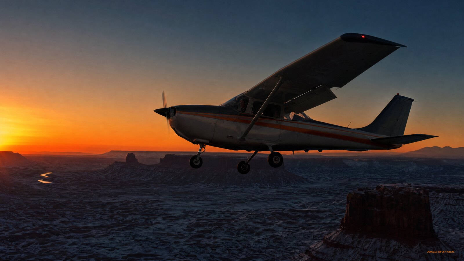 Cessna 172 flying nose-high in slow flight with flaps extended above an Alaskan valley